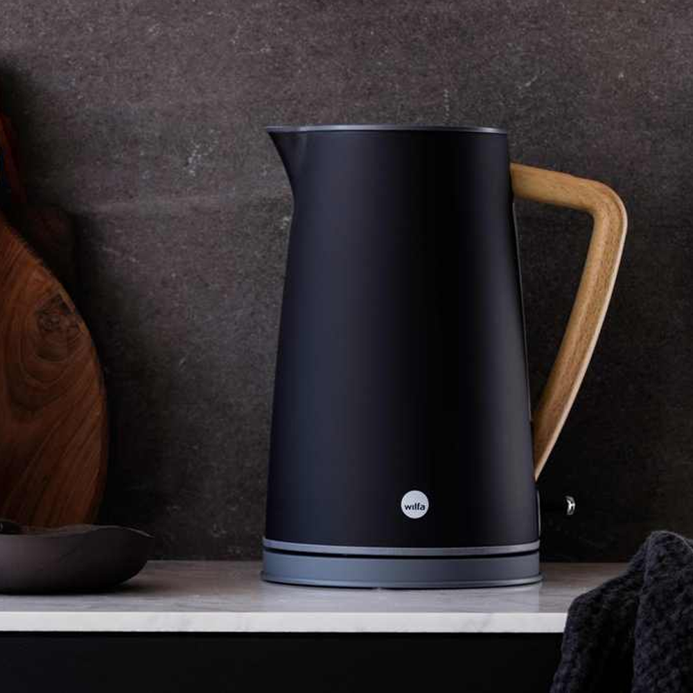 Schwarzer Wasserkocher auf einer Marmorplatte